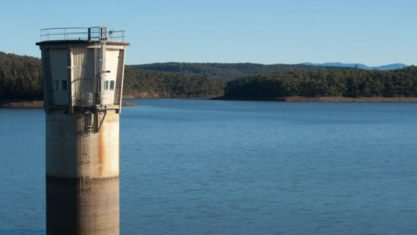 Concrete tower in middle of body of water.