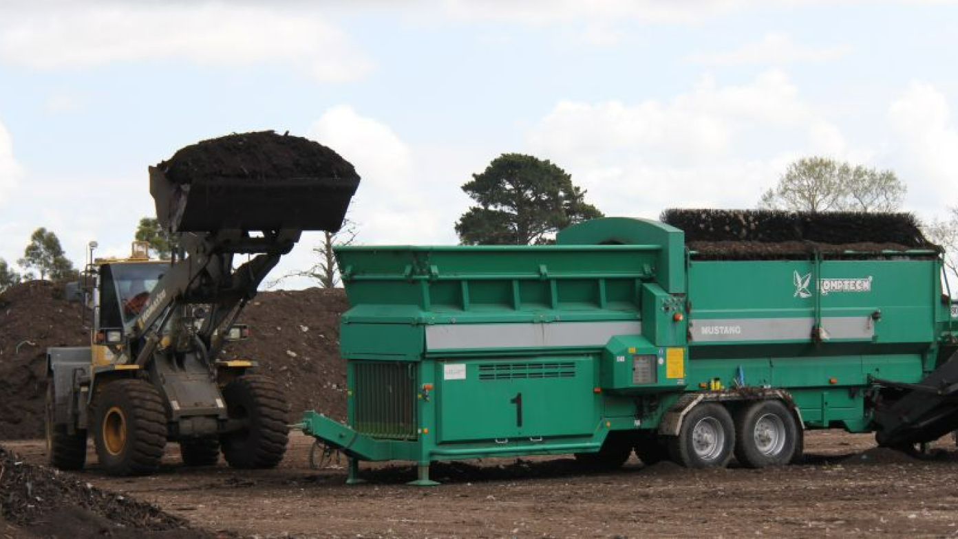 Tractor lifts a pile of dirt. 