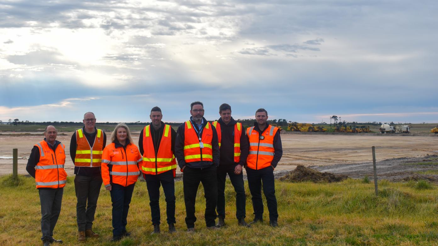 People stand in high vis vest on construction site