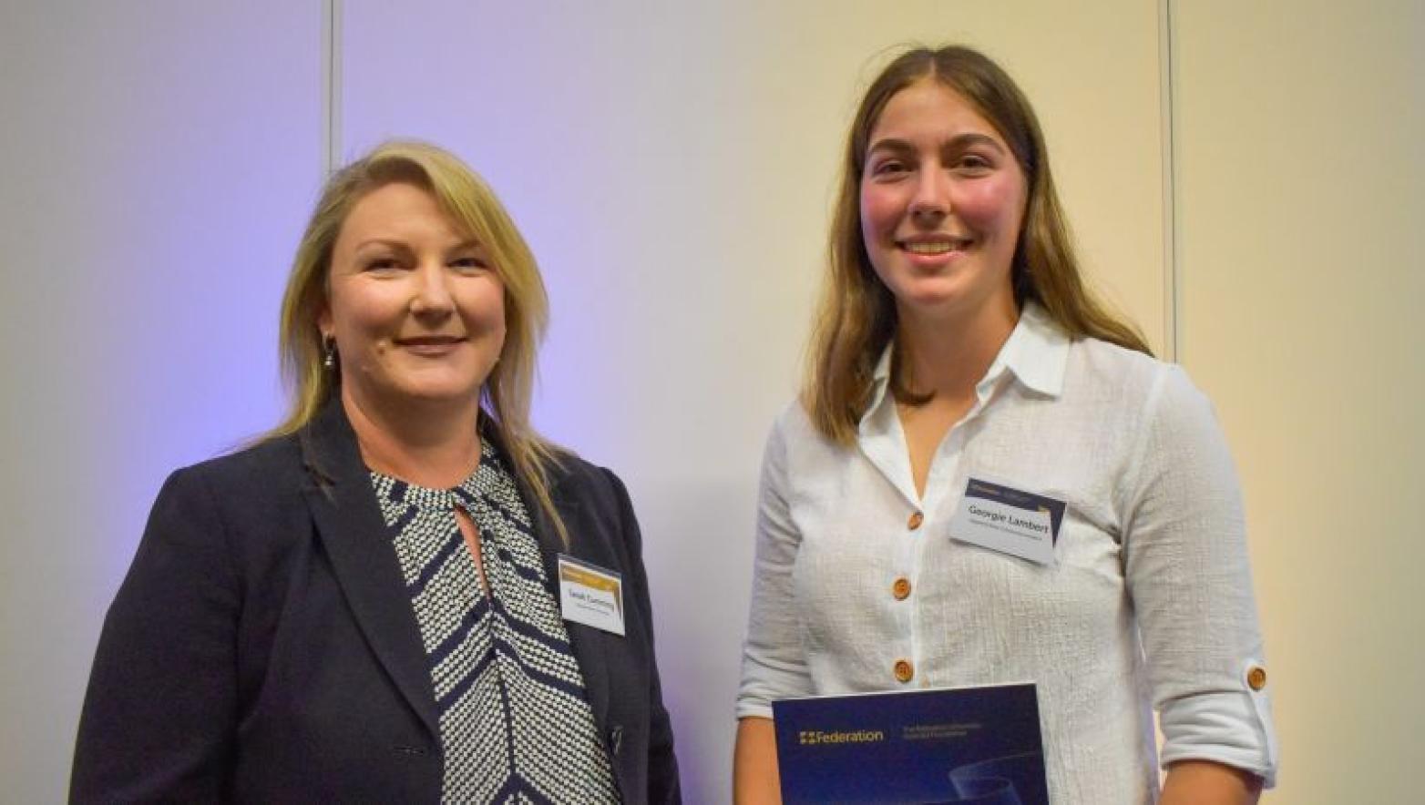 Sarah Cumming and Georgie Lambert stand together smiling. 