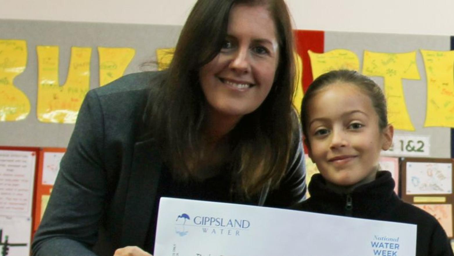 Woman and child hold Gippsland Water certificate. They are smiling. 