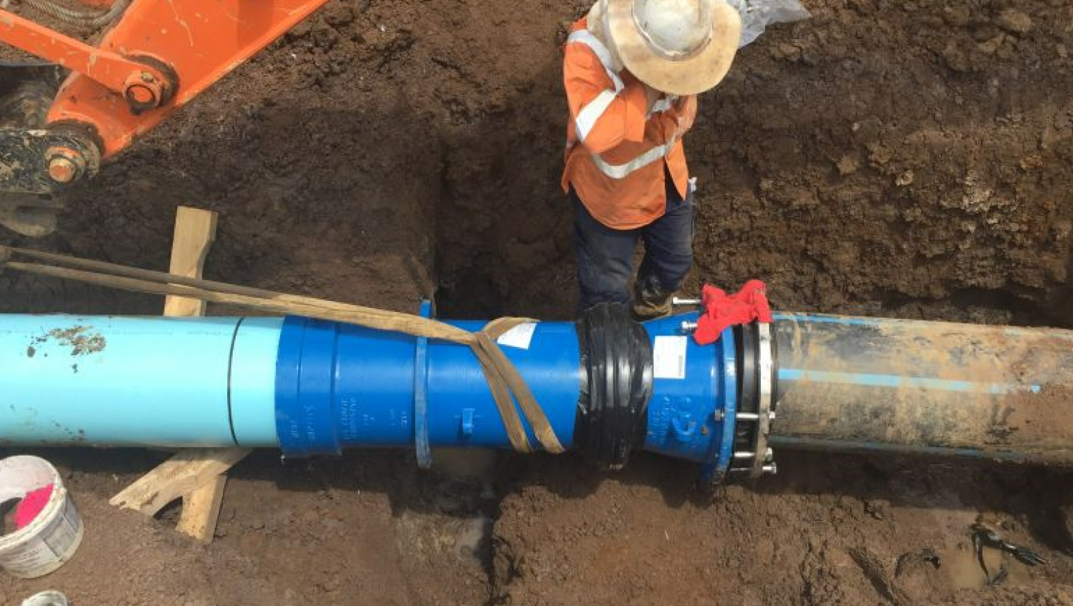 Pipe in ground. Person stands over pipe.