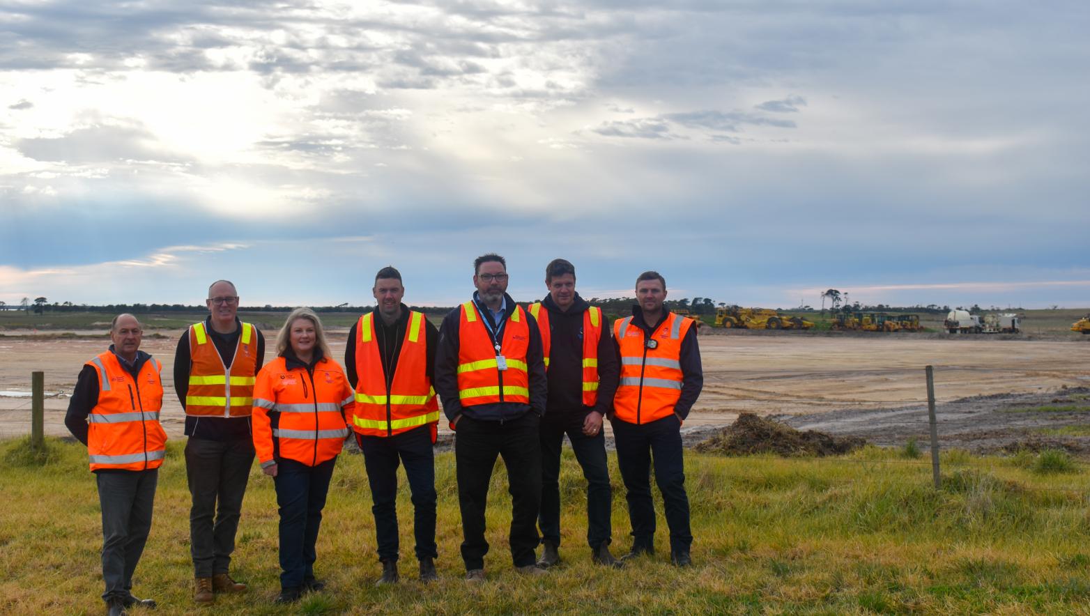 People stand in high vis vest on construction site