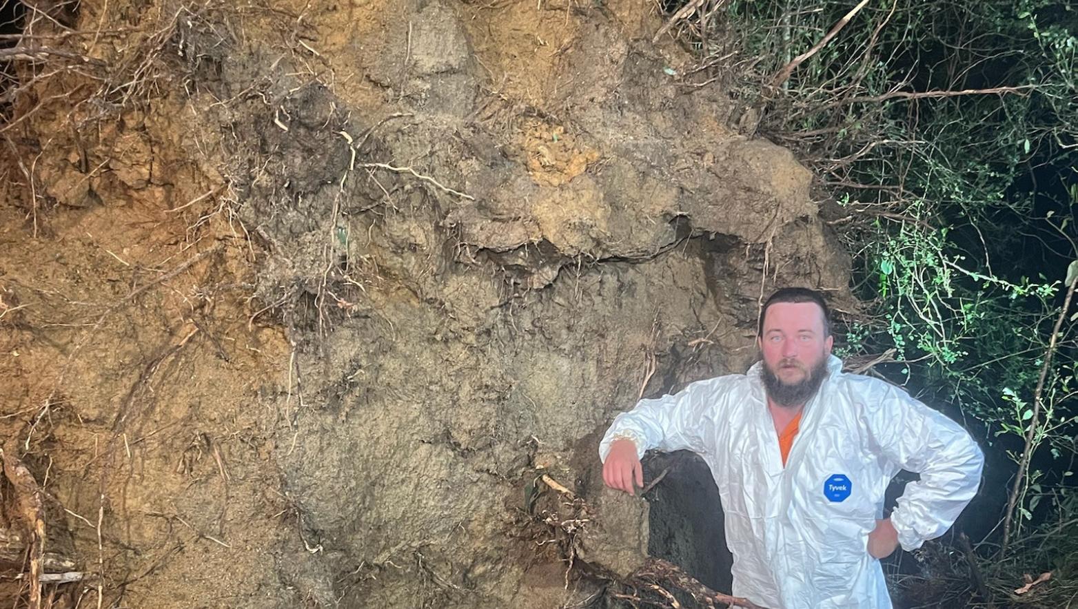 Reece next to a giant tree downed during the storm that devastated the Mirboo North community in February 2024. 